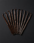 Botte de gousses de vanille Bourbon de Madagascar liee en raphia, fond sombre