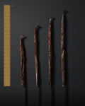 Les quatre calibres de vanille Bourbon alignes sur une regle graduee