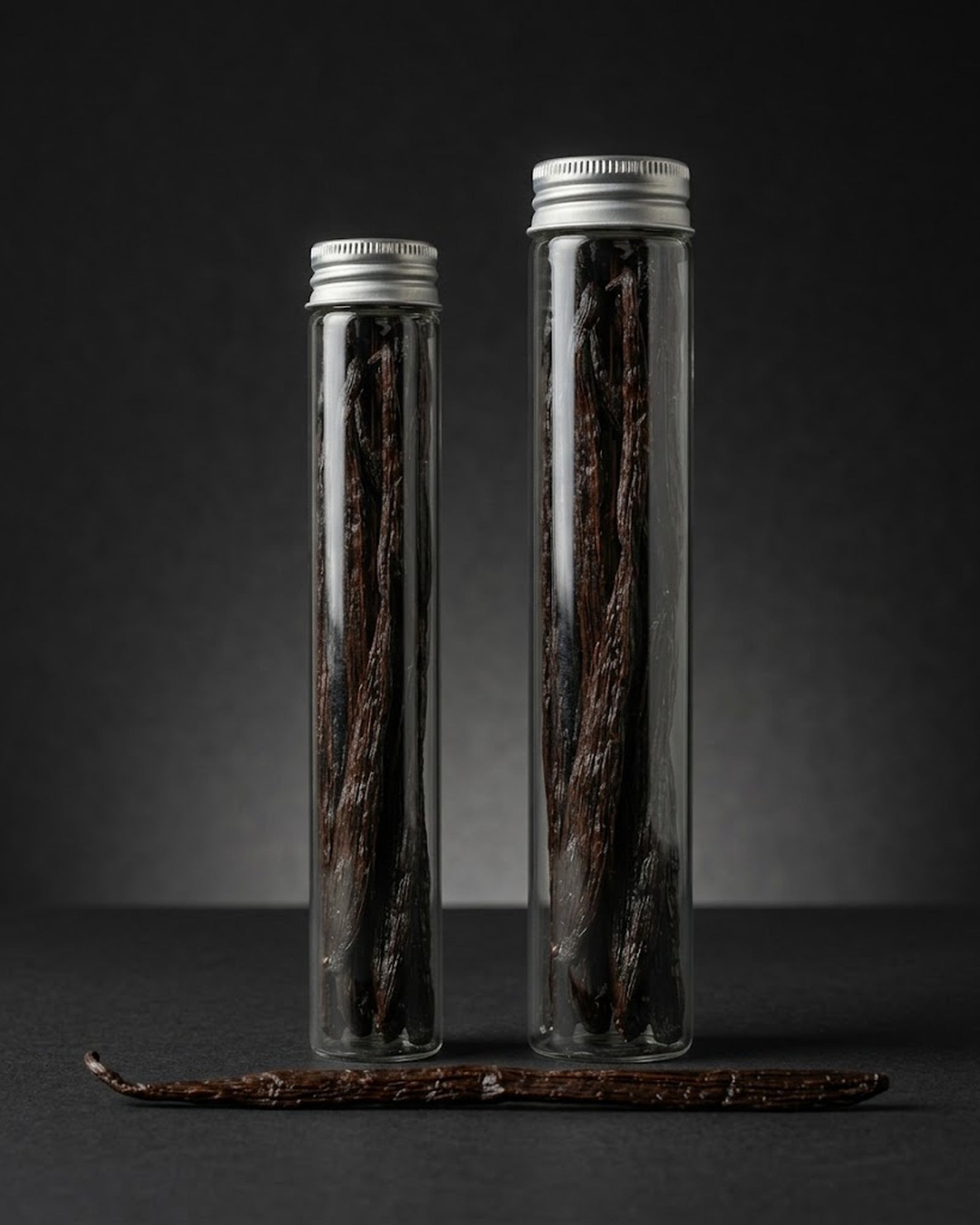 Deux tubes de verre de gousses de vanille Bourbon de Madagascar, cote a cote