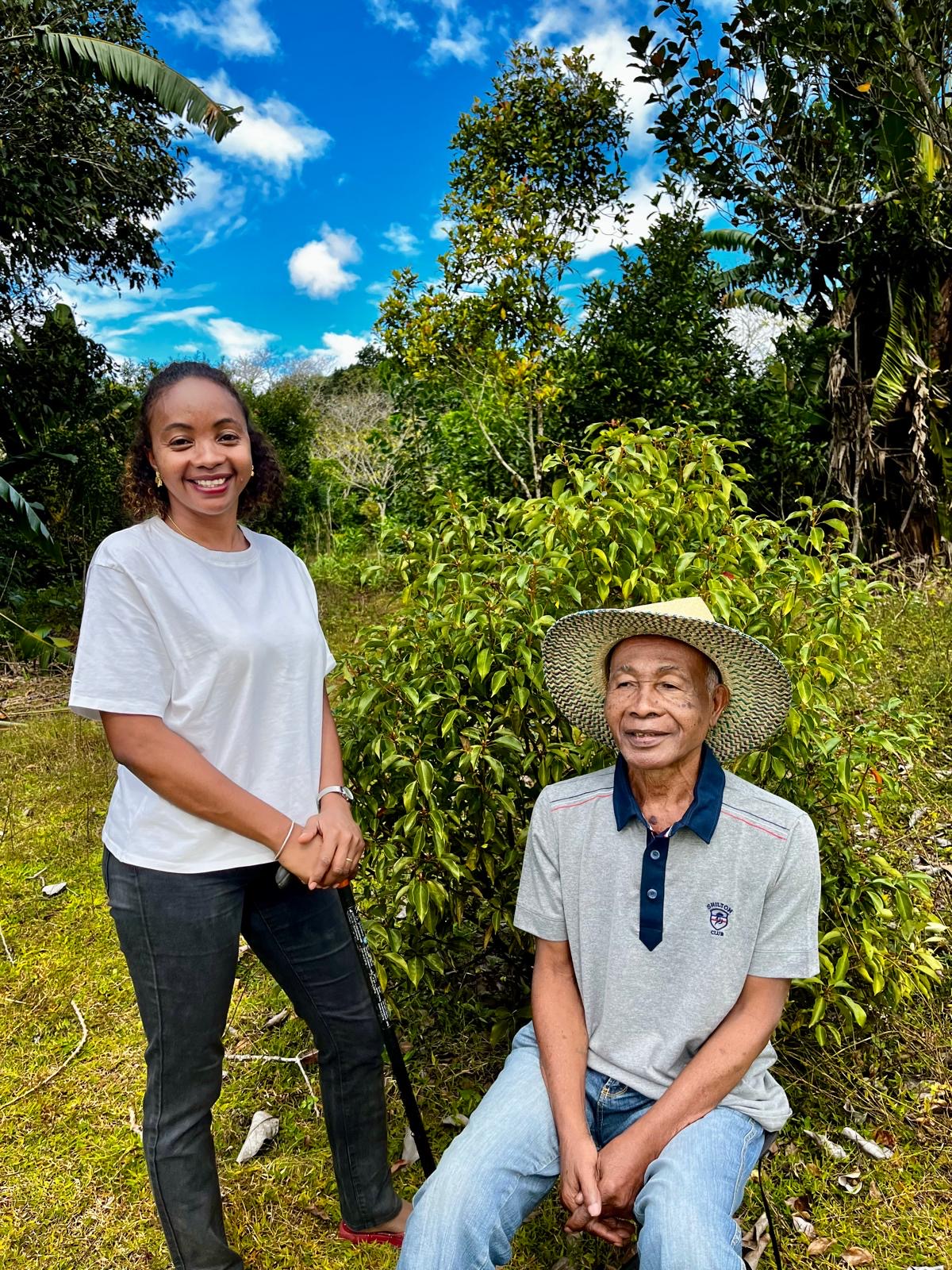 Désiré assis, souriant, une de ses petites-filles à ses côtés